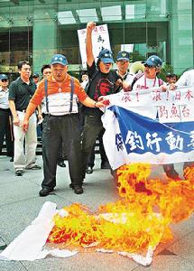 到臺北抗議的本港保釣人士曾健成（左一)、梁國雄(左二)等，焚燒日本國旗。